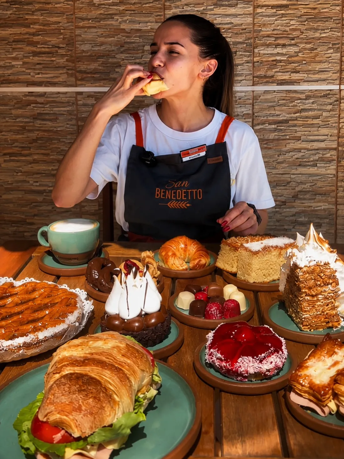 Mesa con medialunas, sándwiches, tortas y café de San Benedetto
